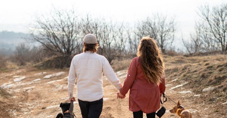 A couple walks hand in hand with their dogs on a rustic path in Slovakia's scenic countryside.