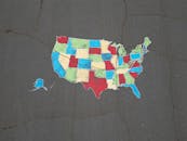 Vibrant map of the USA painted on pavement, showcasing bold state colors.